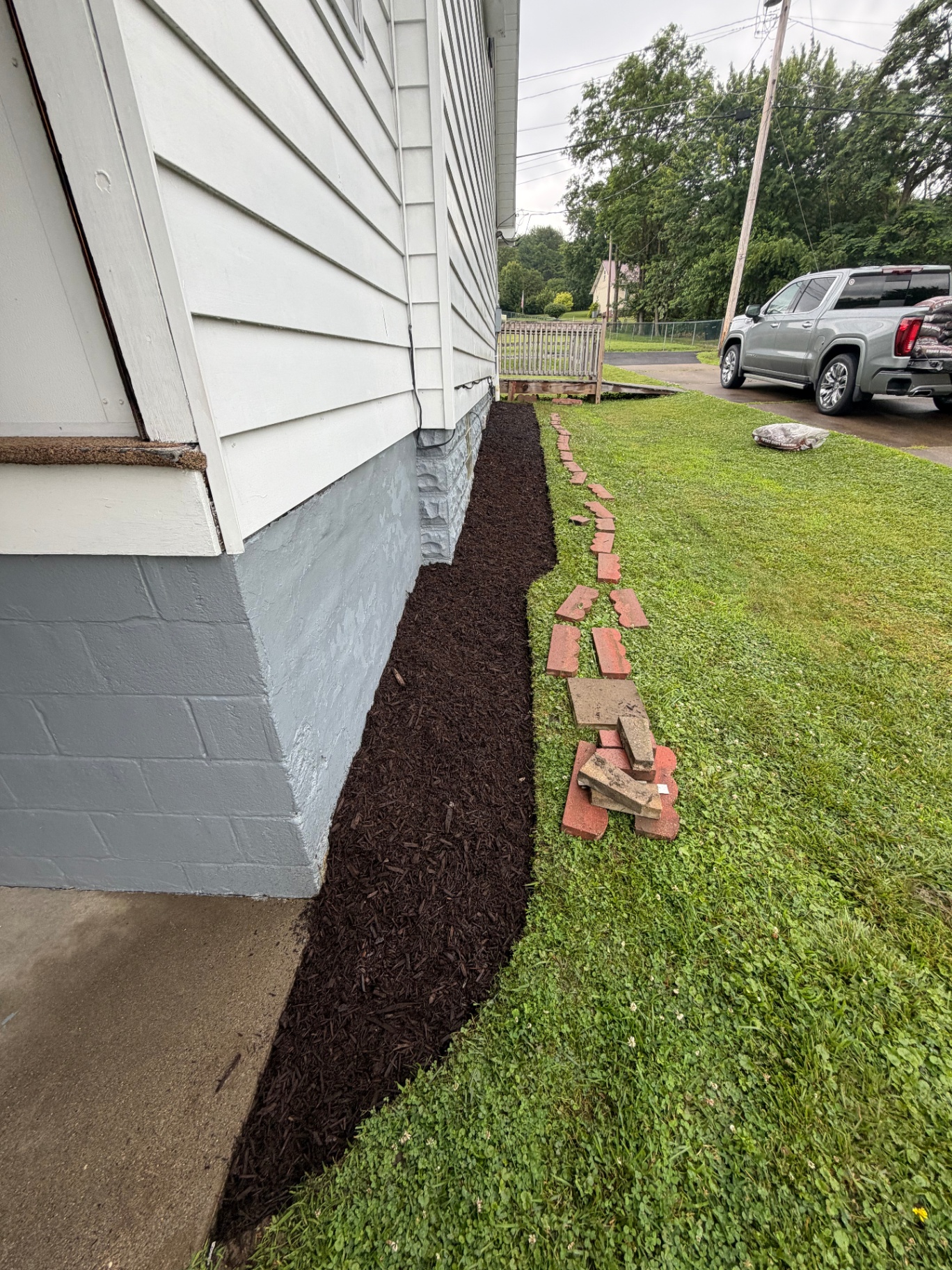 Fresh mulch bed installed along the side of a home with clean edging
