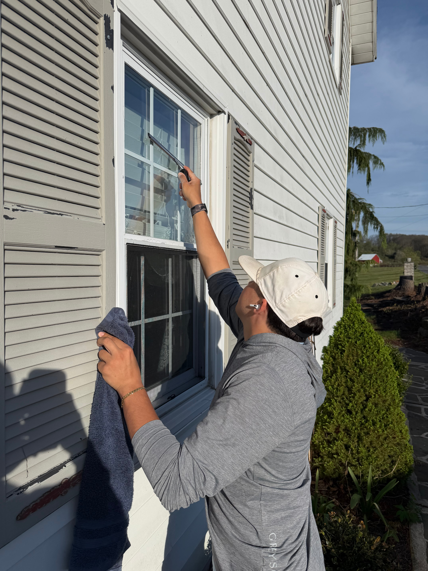 Clean 1's team cleaning an exterior window with squeegee and cloth